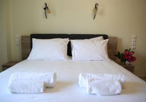 a white bed with two white towels on it at Anna Kavros appartment in Chania Town