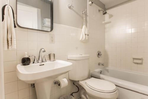 een badkamer met toilet, wastafel en bad bij Kersey Coates at Southmoreland on the Plaza in Kansas City