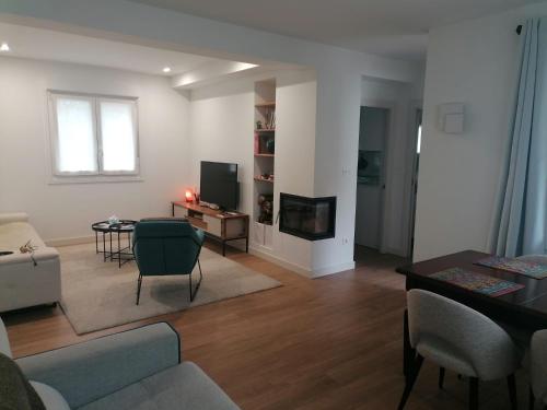 ein Wohnzimmer mit einem Sofa, einem Tisch und einem TV in der Unterkunft El Manzanal - gateway to the mountains and Bilbao in Laudio/Llodio