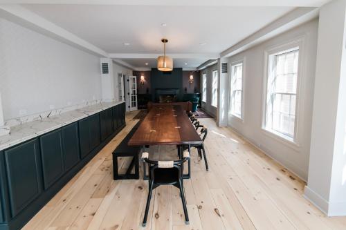 een lange eetkamer met een lange tafel en stoelen bij Old Dutch Inn in Kinderhook