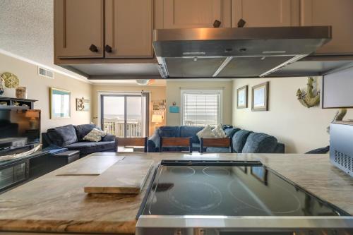 a kitchen and living room with a large island in a room at Coastal Condo with Indoor and Outdoor Pool Access in Emerald Isle