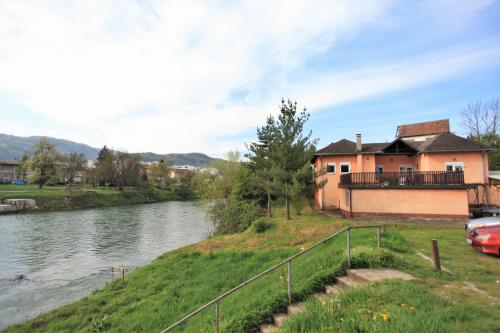 a house on a hill next to a river at Apartmani Brko in Banja Luka