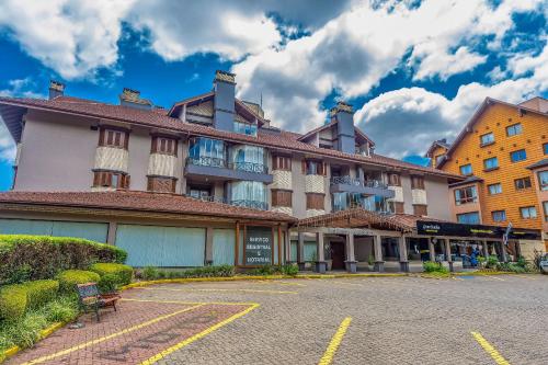 un gran edificio en una calle con aparcamiento en Rosa Edifício Mont Serrat, en Gramado