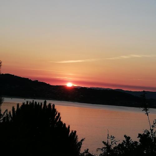 a sunset over a lake with the sun setting at A CASIÑA DA EIRAVELLA in Hio