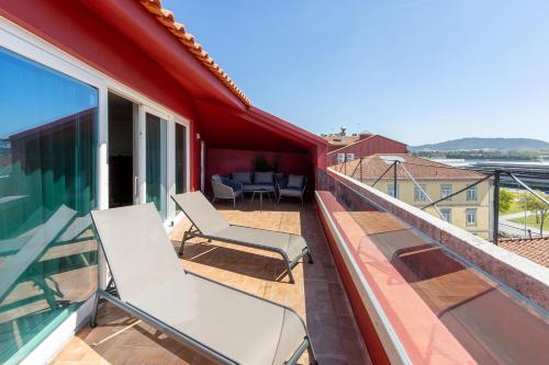 a balcony with white chairs on a roof at AP Dona Aninhas in Viana do Castelo