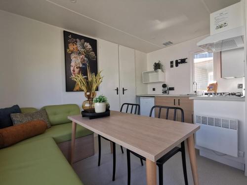 a living room and kitchen with a table and a couch at Chalet Hohllay in Reisdorf