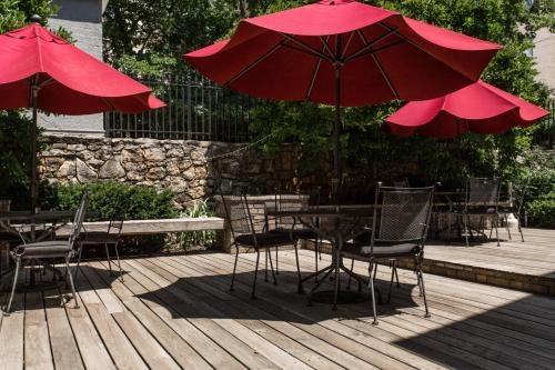 a wooden deck with tables and chairs with red umbrellas at Mary Atkins at Southmoreland on the Plaza in Kansas City