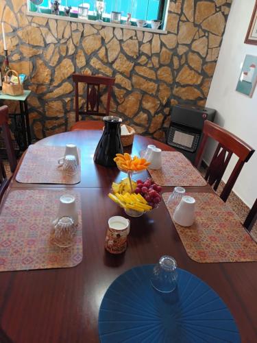 einen Holztisch mit einer Obstschale darauf in der Unterkunft B&B Quinta da Romãzeira in São Bartolomeu de Messines