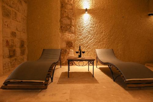 a row of beds in a room with a table at Cappadocia Vita Cave Hotel in Urgup