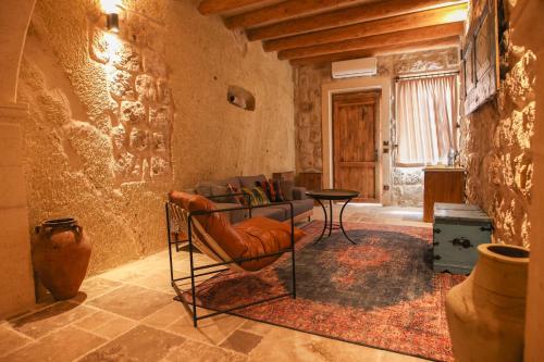 a living room with a chair and a table at Cappadocia Vita Cave Hotel in Urgup
