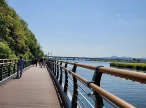 Menschen, die auf einer Brücke über einen Wasserkörper laufen in der Unterkunft Hosandong House in Daegu