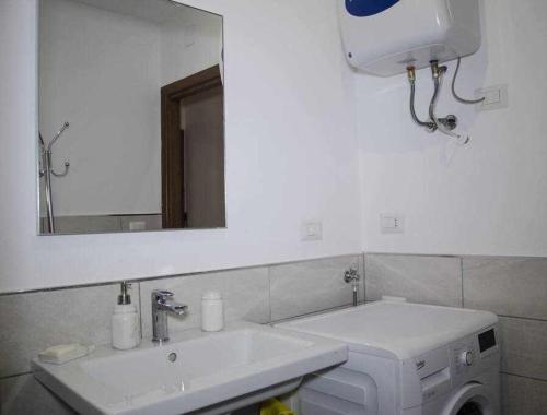 y baño con lavabo blanco y espejo. en Bilocale Fronte Mare Sparaglione en Sassari