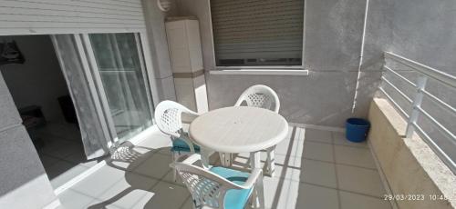 uma mesa branca e cadeiras numa varanda em Apartamento Aquarium Park, 1ª linea de playa, para 4 personas em Calpe