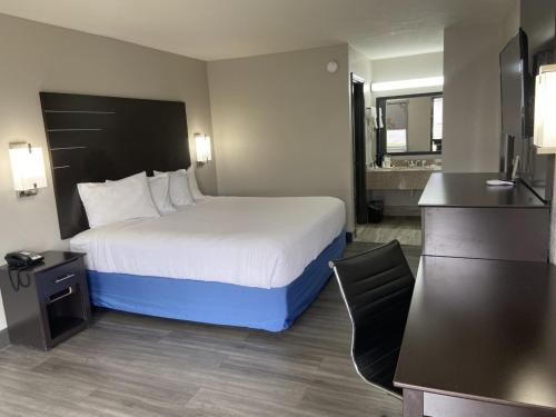 a hotel room with a bed and a bathroom at Days Inn by Wyndham Moss Point Pascagoula in Moss Point