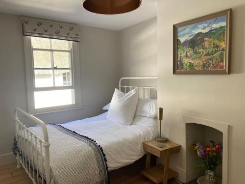 a bedroom with a bed and a painting on the wall at Littlecot in Malborough