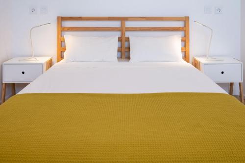 a bedroom with a large bed with two night stands at Bétula Studios in Bragança