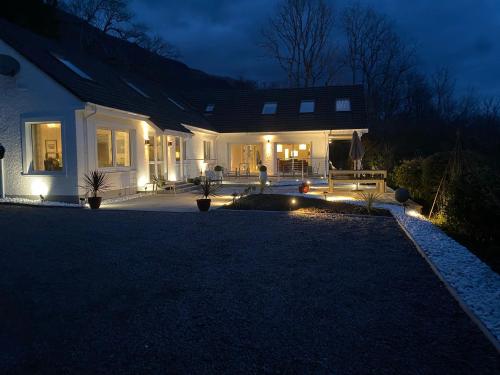 a house with lights on the front of it at night at Invercreran Lodge Luxury Bed & Breakfast in Appin