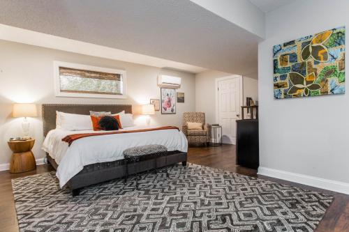 a bedroom with a large bed and a rug at Charlie Bird Parker Suite at Southmoreland on the Plaza in Kansas City