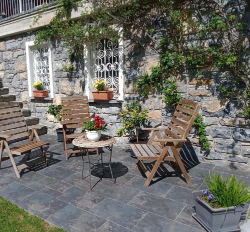 een patio met 2 stoelen en een tafel en een aantal planten bij Il Giardino di Crès in Esino Lario