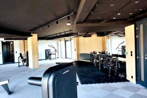 un gimnasio con equipo cardiovascular en una habitación grande en Gdańsk Porto Apartments, en Gdansk