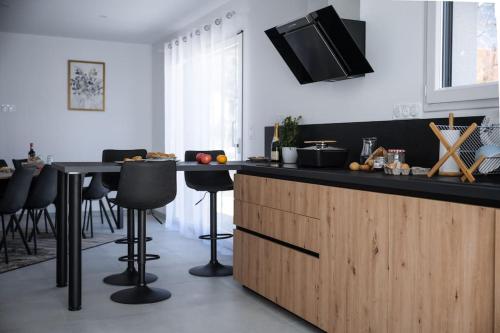 une cuisine avec un comptoir et une table avec des tabourets dans l'établissement Le Clos De L'étang Jura, à Frasne