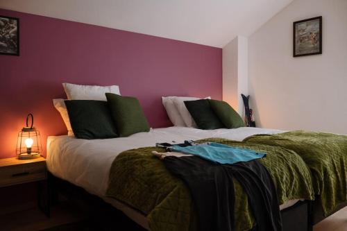 - une chambre avec un grand lit et un mur pourpre dans l'établissement Le Clos De L'étang Jura, à Frasne