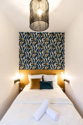 - une chambre avec un lit blanc et une grande tête de lit dans l'établissement Le Belvédère - Résidence Hestia, à Saint-Étienne