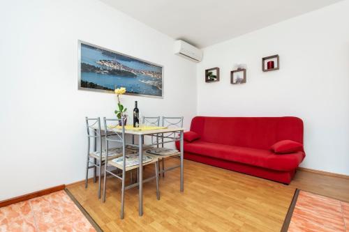 a living room with a red couch and a table at Apartment Zaneto in Rovinjsko Selo