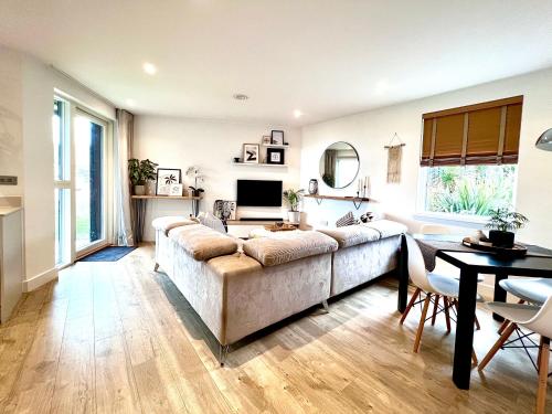 sala de estar con sofá y mesa en Luxury Sunrise to Sunset Beachfront Apartment, en Perranporth