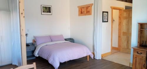 - une chambre avec un lit et une couverture violette dans l'établissement Beautiful Home on Sunny Acreage, à Lunenburg