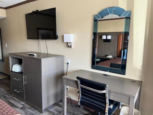 a hotel room with a desk and a mirror at Highland Inn Las Vegas in Las Vegas