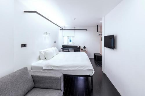 a bedroom with a bed and a couch at Hotel Mono in Singapore