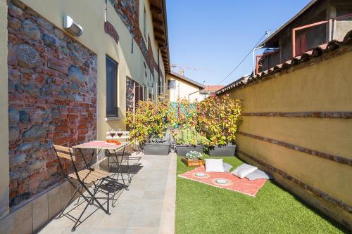 a patio with a table and chairs on the grass at Cascina 6b in San Maurizio Canavese
