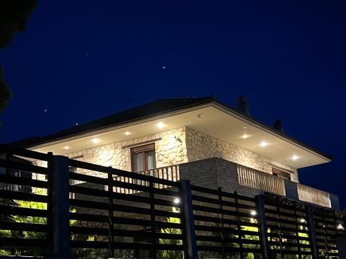 a house with a fence in front of it at night at Heraklia villa sea view in Nea Iraklia