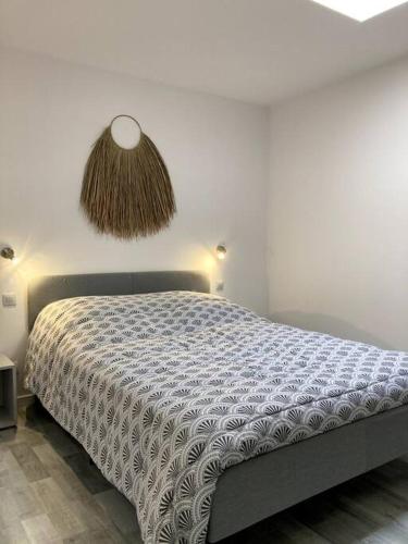 une chambre avec un lit avec une couette dessus dans l'établissement Maison 2 chambres port de plaisance, au Le Verdon-sur-Mer