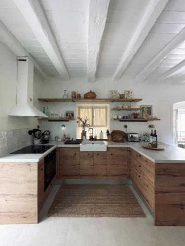 a large kitchen with wooden cabinets and a white ceiling at Nespola di Campiello in Corfu