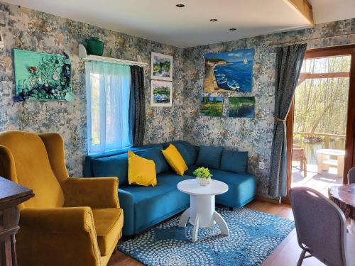 a living room with a blue couch and yellow pillows at Dom Rybaka in Mirosławiec
