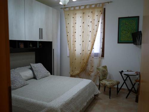 ein Schlafzimmer mit einem Bett, einem Stuhl und einem Fenster in der Unterkunft Il nido di Angelina - Ascea in Ascea