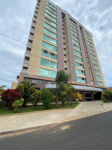 a tall building with palm trees in front of it at Piazza diRoma com acesso ao Acqua Park e Splash in Caldas Novas