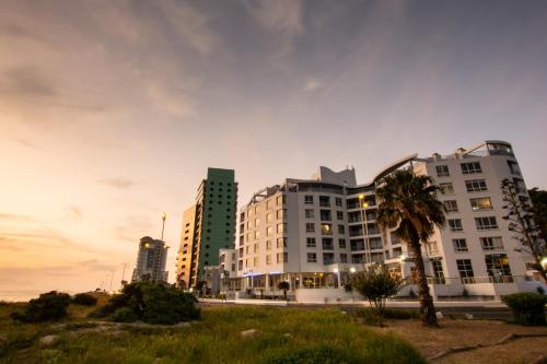 a city skyline with tall buildings and a palm tree at Ocean Breeze Hotel in Strand