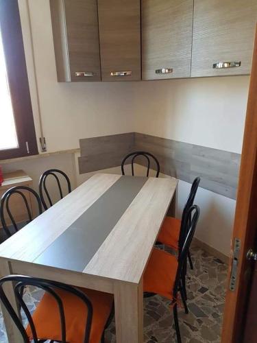 einen Holztisch und Stühle in der Küche in der Unterkunft Appartamento piazza Marciano' in Bellaria-Igea Marina