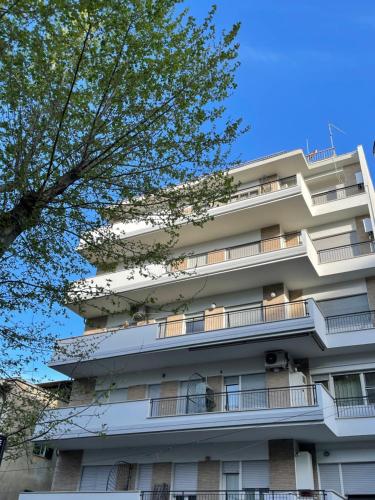 un edificio de apartamentos con balcones y un árbol en A Due Passi dal Castello - Appartamento con Vista, en Bracciano