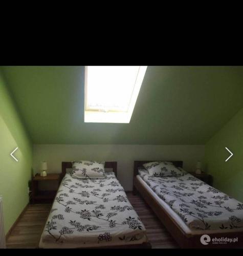 1 dormitorio con 2 camas y ventana en Studio Rodzinne ZACISZE, en Mikołajki