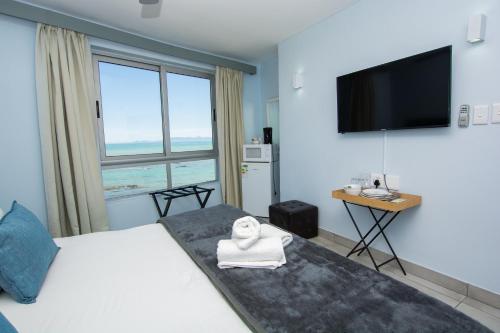 a hotel room with a bed and a large window at Ocean Breeze Hotel in Strand