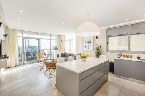 a kitchen and living room with a table and chairs at Modern 3-BR near Beach Club by HolyGuest in Tel Aviv