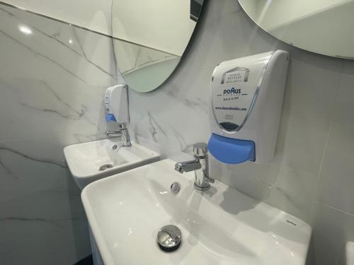 un bagno con lavandino e dispenser di sapone sul muro di Eurocity Hotel Santander Centro a Santander