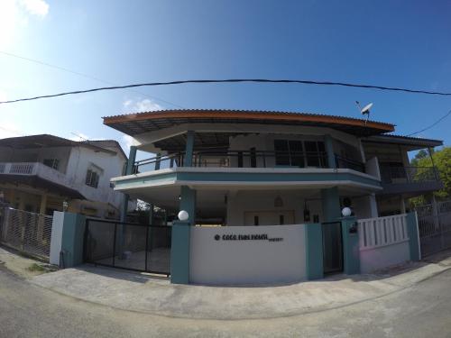 a house with a fence in front of it at CoCo Fun House Kemaman with Pool and Bathtub in Kampong Gong Pauh