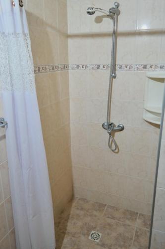 y baño con ducha y cortina de ducha. en Casa Picaflor UY en Jaureguiberry