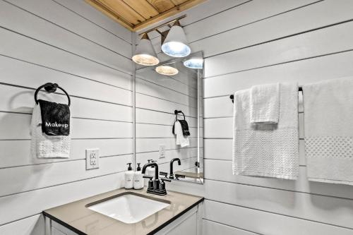 a white bathroom with a sink and towels at Smoke of the Mountains in Gatlinburg