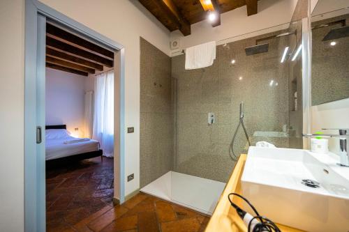 a bathroom with a shower and a sink and a bed at Casa Viola in Bergamo